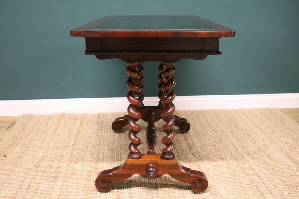 A William IV Goncalo Alves writing table featuring a dark green leather inset top, twin barley twist leg supports, and a central turned stretcher. View XII