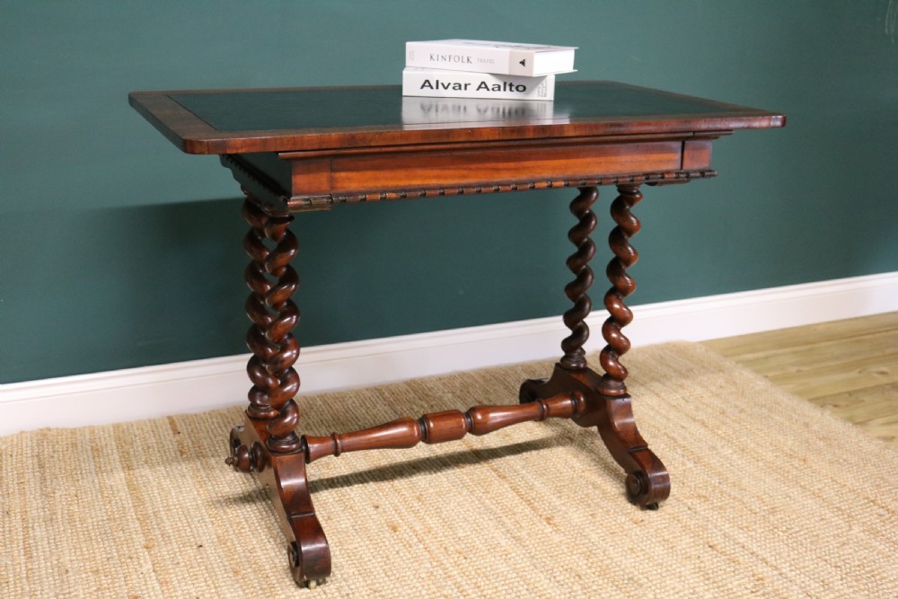 A William IV Goncalo Alves writing table featuring a dark green leather inset top, twin barley twist leg supports, and a central turned stretcher. View XIV