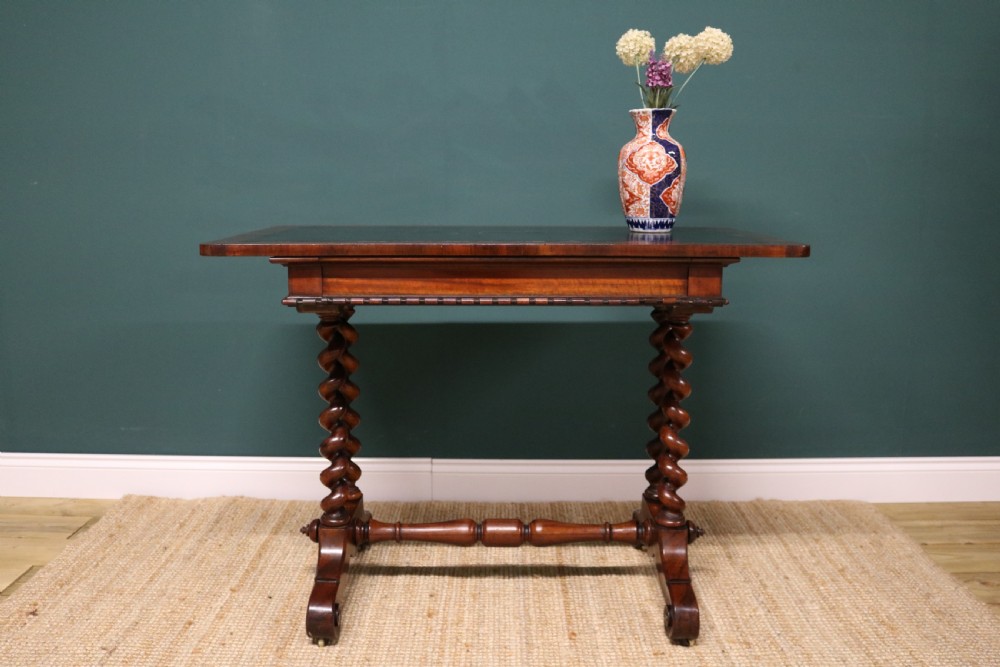 A William IV Goncalo Alves writing table featuring a dark green leather inset top, twin barley twist leg supports, and a central turned stretcher. View XV