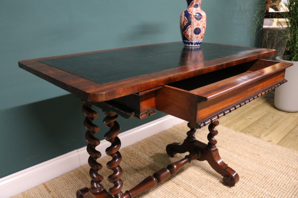 A William IV Goncalo Alves writing table featuring a dark green leather inset top, twin barley twist leg supports, and a central turned stretcher. View XVII