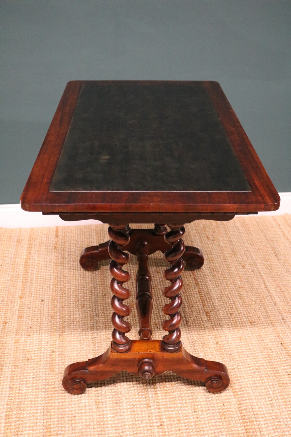 A William IV Goncalo Alves writing table featuring a dark green leather inset top, twin barley twist leg supports, and a central turned stretcher. View XVIII