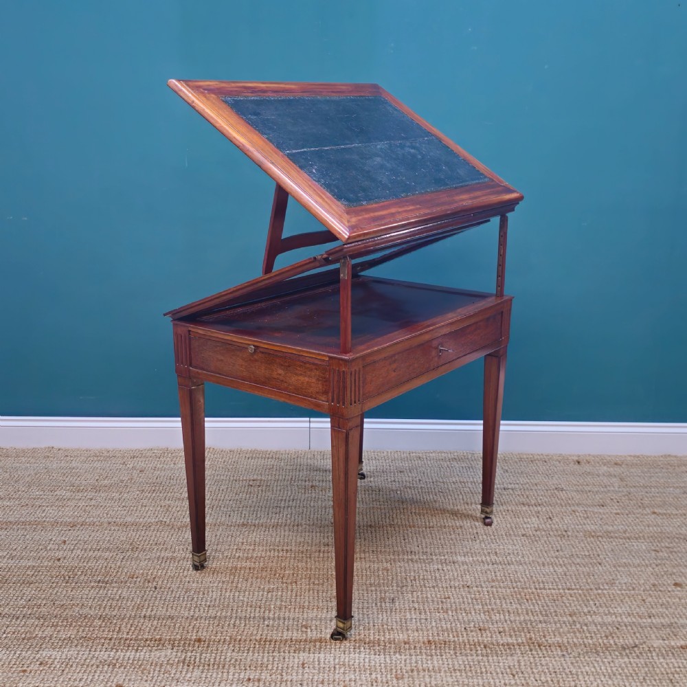 A nineteenth-century French mahogany architects desk featuring a leather inset top, single apron drawer, fluted corners, and tapered legs on brass castors. View VIII
