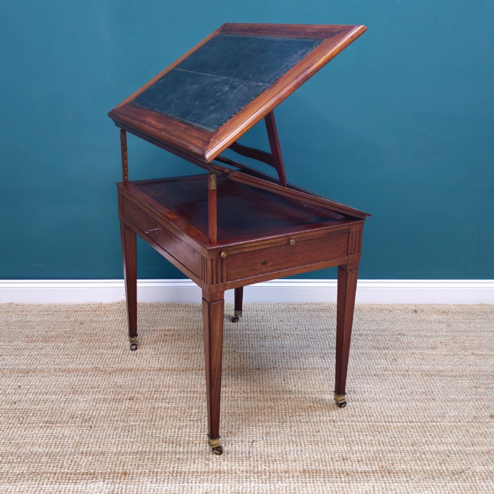A nineteenth-century French mahogany architects desk featuring a leather inset top, single apron drawer, fluted corners, and tapered legs on brass castors. View II