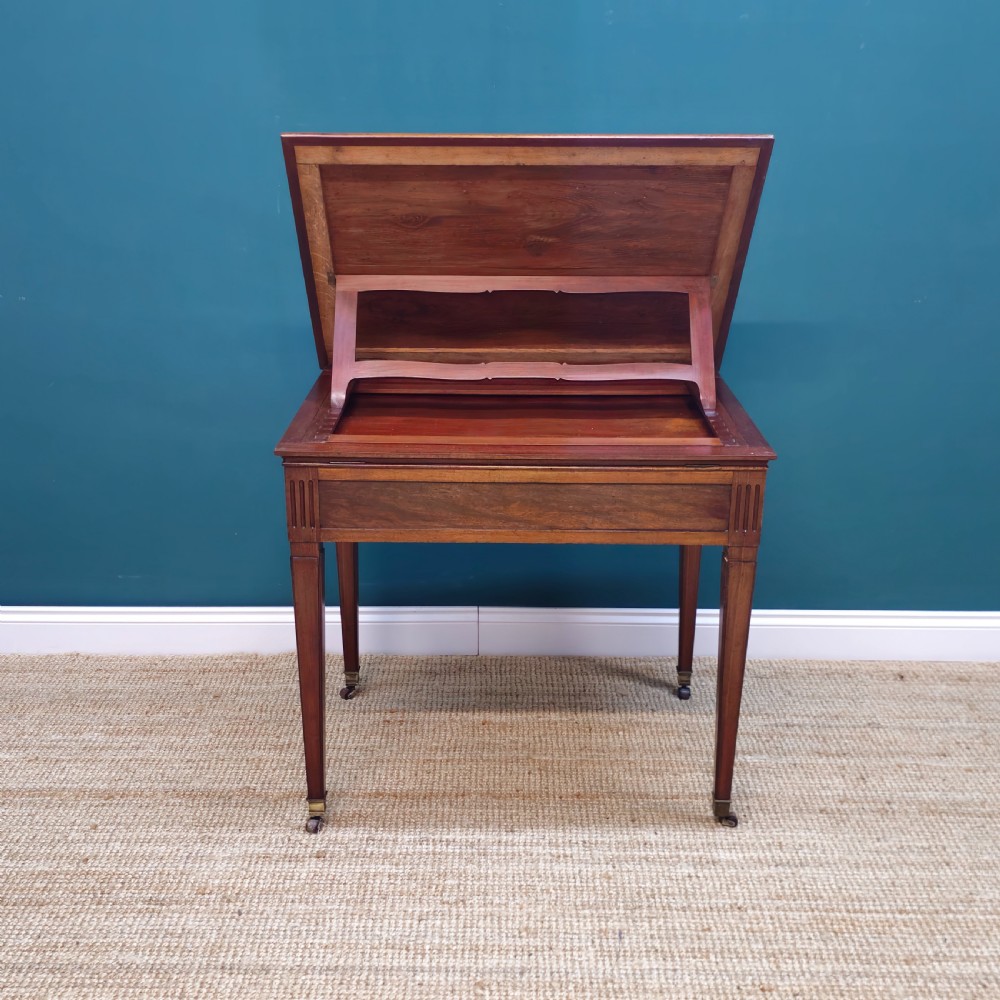A nineteenth-century French mahogany architects desk featuring a leather inset top, single apron drawer, fluted corners, and tapered legs on brass castors. View III