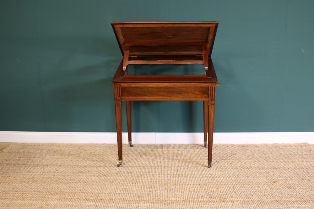 A nineteenth-century French mahogany architects desk featuring a leather inset top, single apron drawer, fluted corners, and tapered legs on brass castors. View XI