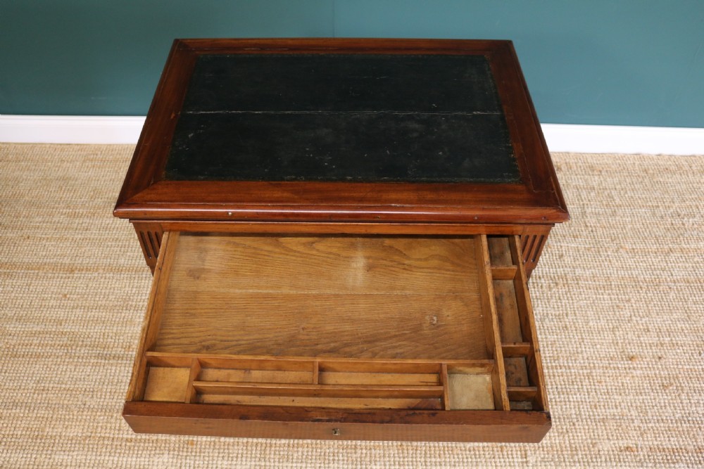 A nineteenth-century French mahogany architects desk featuring a leather inset top, single apron drawer, fluted corners, and tapered legs on brass castors. View XII
