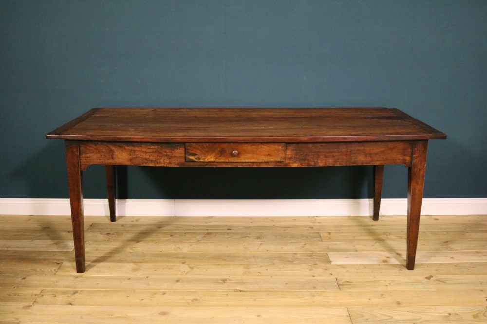 An antique French fruitwood farmhouse table featuring a rectangular plank top, a single frieze drawer with a wooden knob, and square tapered legs. View II