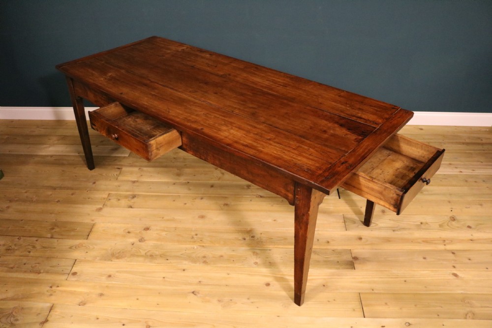 An antique French fruitwood farmhouse table featuring a rectangular plank top, a single frieze drawer with a wooden knob, and square tapered legs. View IV