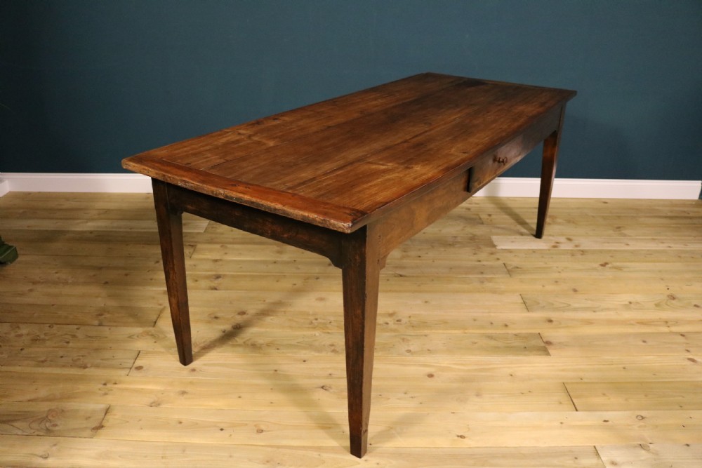 An antique French fruitwood farmhouse table featuring a rectangular plank top, a single frieze drawer with a wooden knob, and square tapered legs. View VII