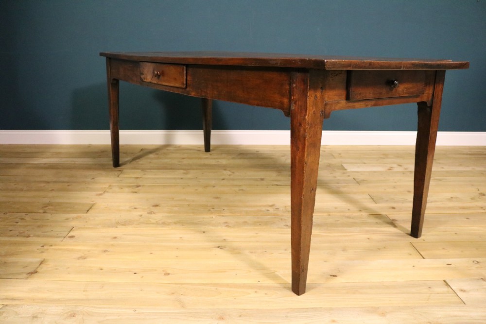 An antique French fruitwood farmhouse table featuring a rectangular plank top, a single frieze drawer with a wooden knob, and square tapered legs. View X