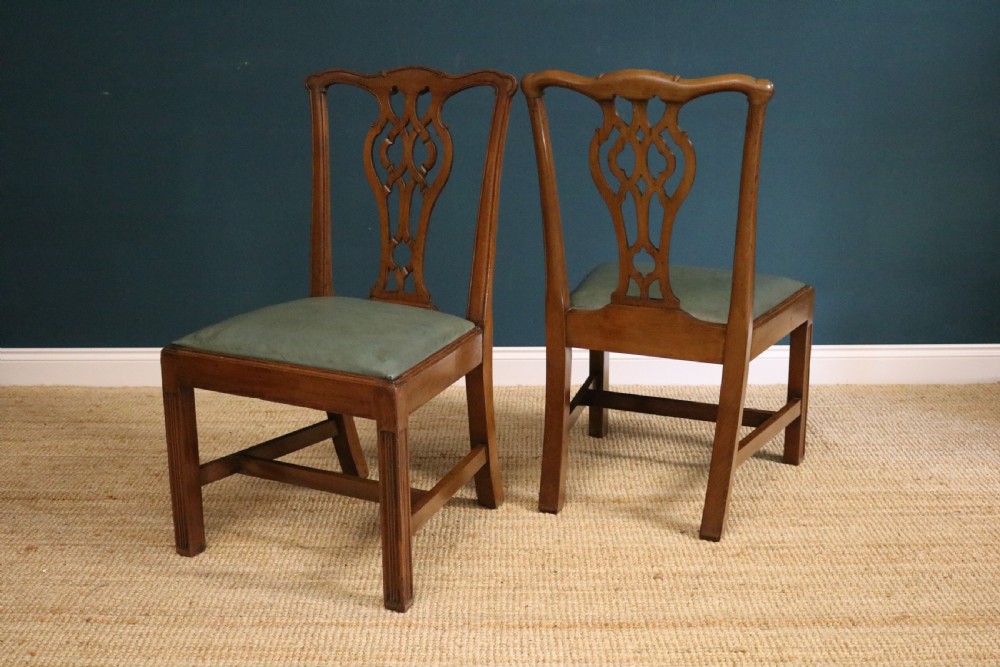A set of six George III style mahogany dining chairs with carved pierced back splats and green leather drop-in seats. View II