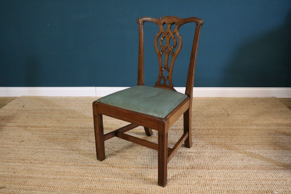 A set of six George III style mahogany dining chairs with carved pierced back splats and green leather drop-in seats. View VI