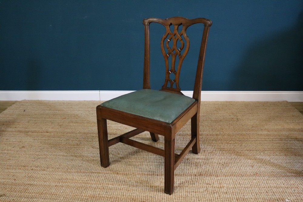 A set of six George III style mahogany dining chairs with carved pierced back splats and green leather drop-in seats. View VII