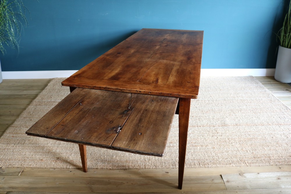 A nineteenth-century French farmhouse table constructed from warm brown cherry wood with tapered square legs and a rectangular plank top. View II