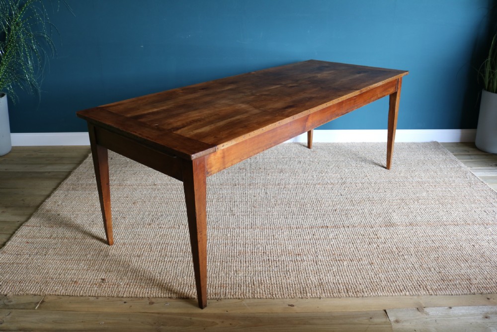 A nineteenth-century French farmhouse table constructed from warm brown cherry wood with tapered square legs and a rectangular plank top. View VI