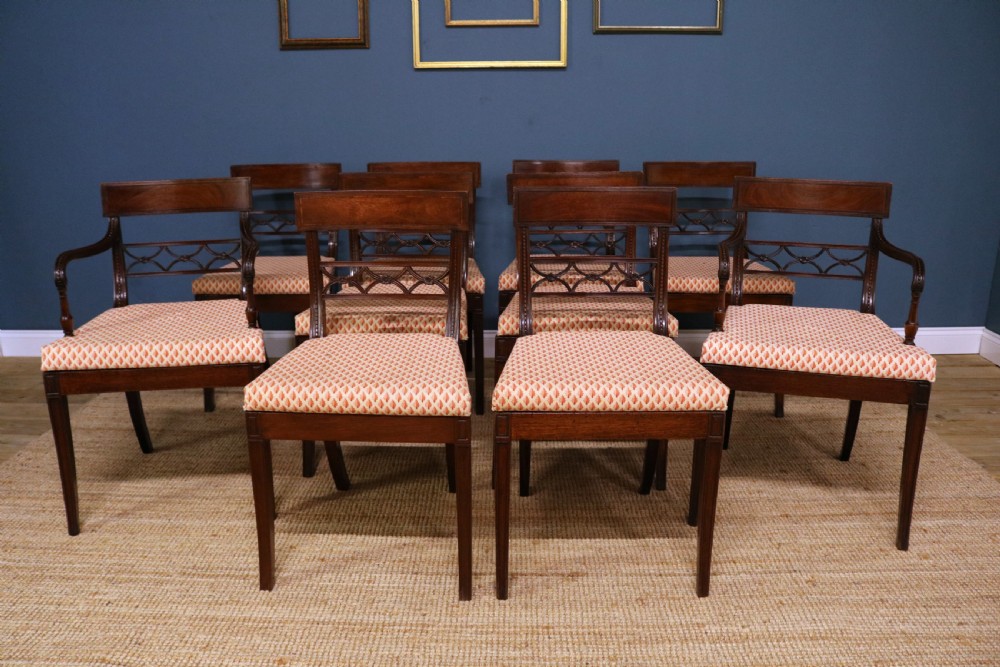 A set of ten Regency style mahogany dining chairs featuring hand-woven cane seats, tablet top rails, geometric carved splats, and two matching carver armchairs. View II