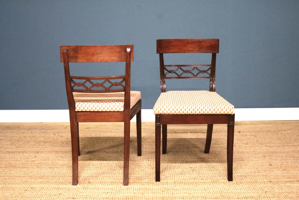 A set of ten Regency style mahogany dining chairs featuring hand-woven cane seats, tablet top rails, geometric carved splats, and two matching carver armchairs. View VIII