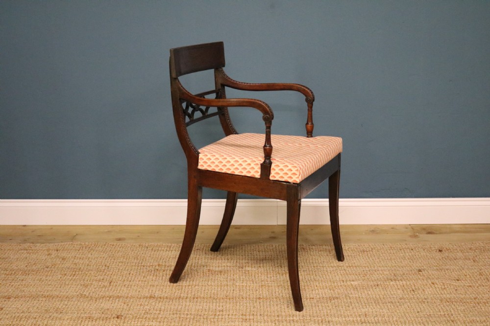A set of ten Regency style mahogany dining chairs featuring hand-woven cane seats, tablet top rails, geometric carved splats, and two matching carver armchairs. View IX