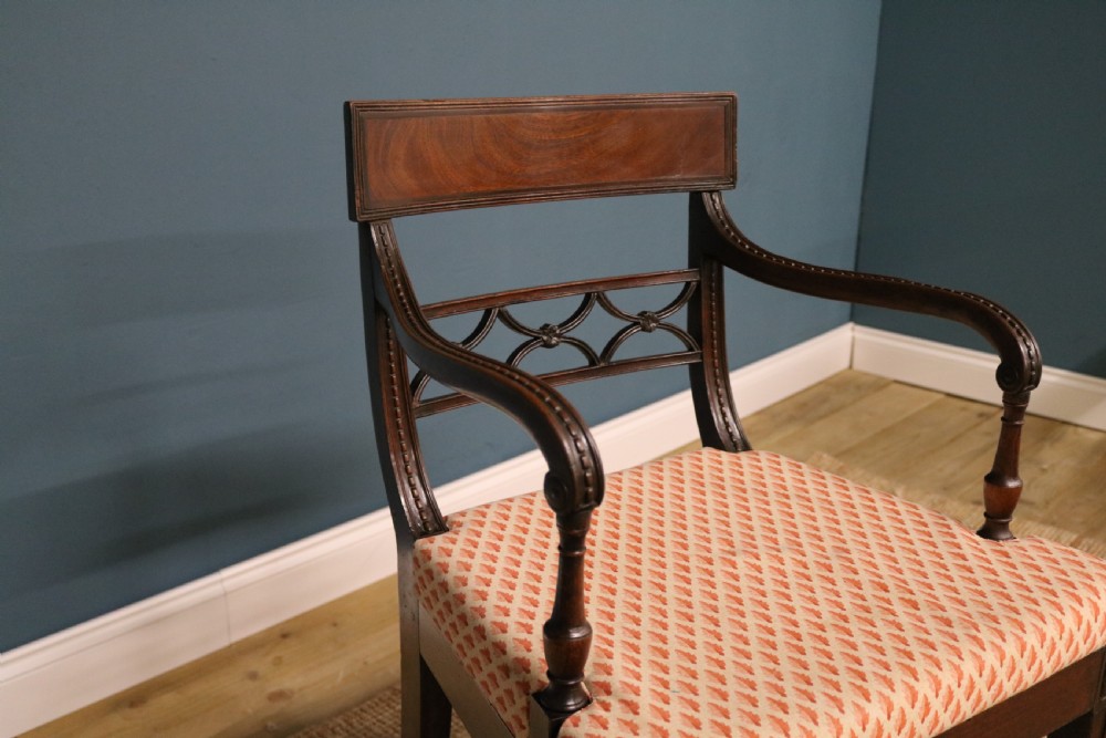 A set of ten Regency style mahogany dining chairs featuring hand-woven cane seats, tablet top rails, geometric carved splats, and two matching carver armchairs. View XI