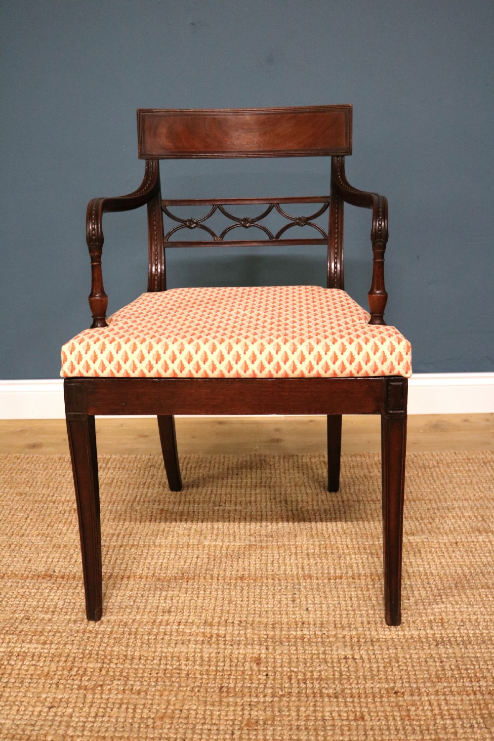 A set of ten Regency style mahogany dining chairs featuring hand-woven cane seats, tablet top rails, geometric carved splats, and two matching carver armchairs. View XII