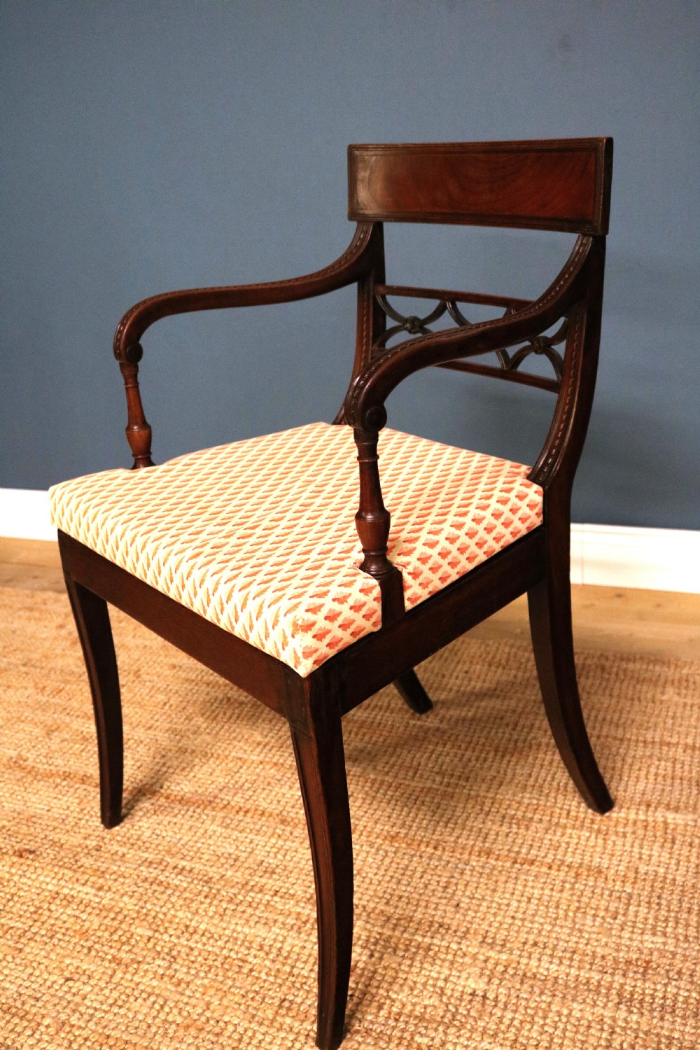 A set of ten Regency style mahogany dining chairs featuring hand-woven cane seats, tablet top rails, geometric carved splats, and two matching carver armchairs. View XIII