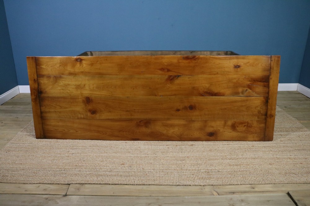 A long French cherry wood dining table featuring a scalloped apron, tapered legs, and a low stretcher base. View II