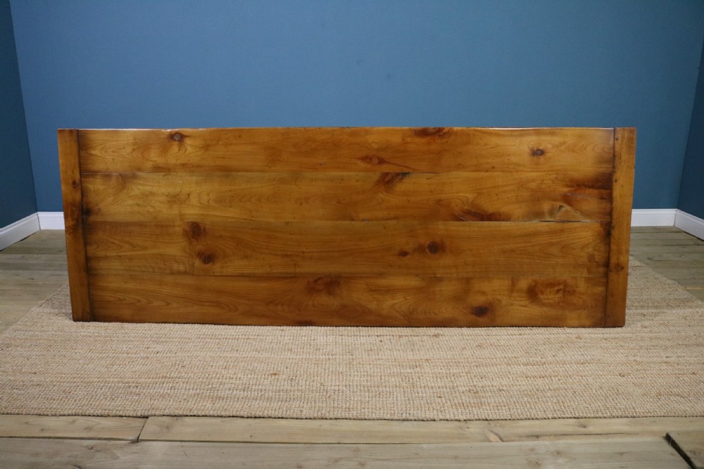 A long French cherry wood dining table featuring a scalloped apron, tapered legs, and a low stretcher base. View III