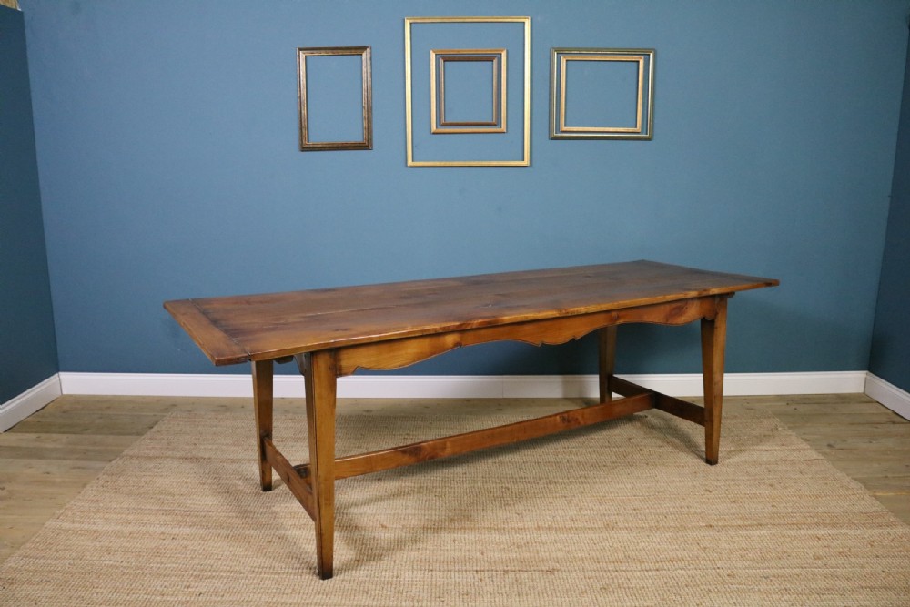 A long French cherry wood dining table featuring a scalloped apron, tapered legs, and a low stretcher base. View IV