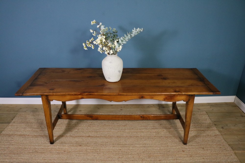 A long French cherry wood dining table featuring a scalloped apron, tapered legs, and a low stretcher base. View IX