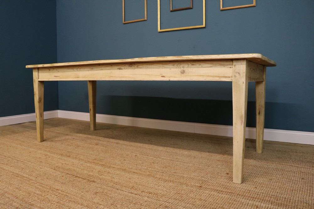 A long rectangular bleached pine dining table supported by four square tapered legs and a simple straight apron. View II