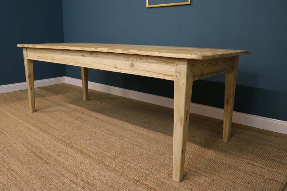 A long rectangular bleached pine dining table supported by four square tapered legs and a simple straight apron. View III