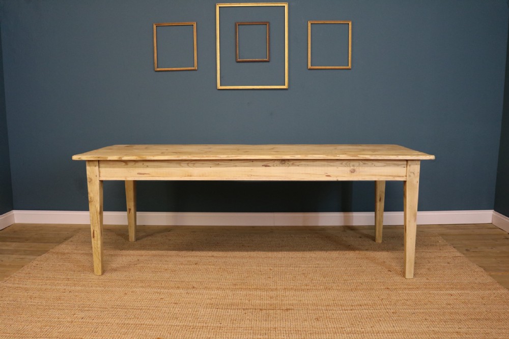 A long rectangular bleached pine dining table supported by four square tapered legs and a simple straight apron. View IV