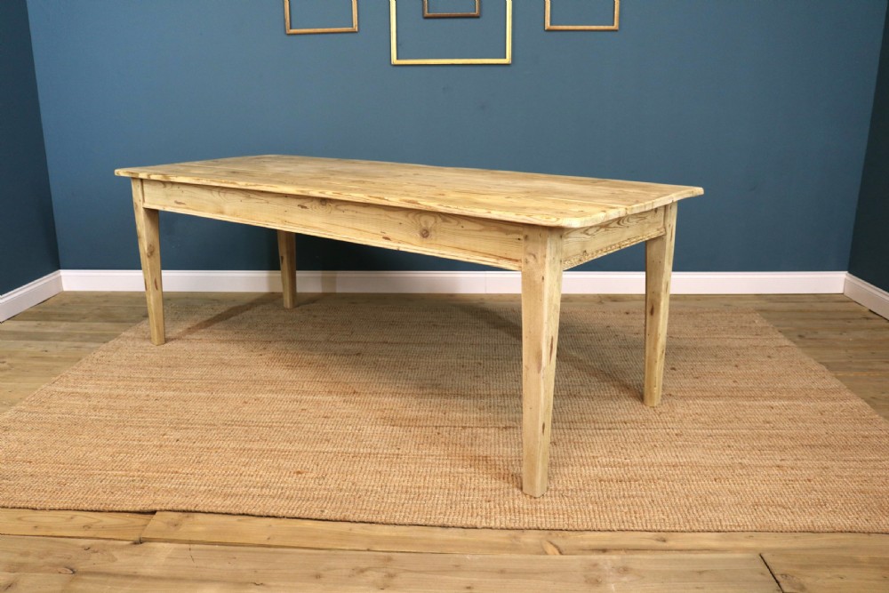 A long rectangular bleached pine dining table supported by four square tapered legs and a simple straight apron. View V
