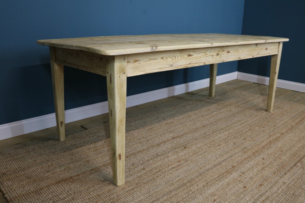 A long rectangular bleached pine dining table supported by four square tapered legs and a simple straight apron. View IX