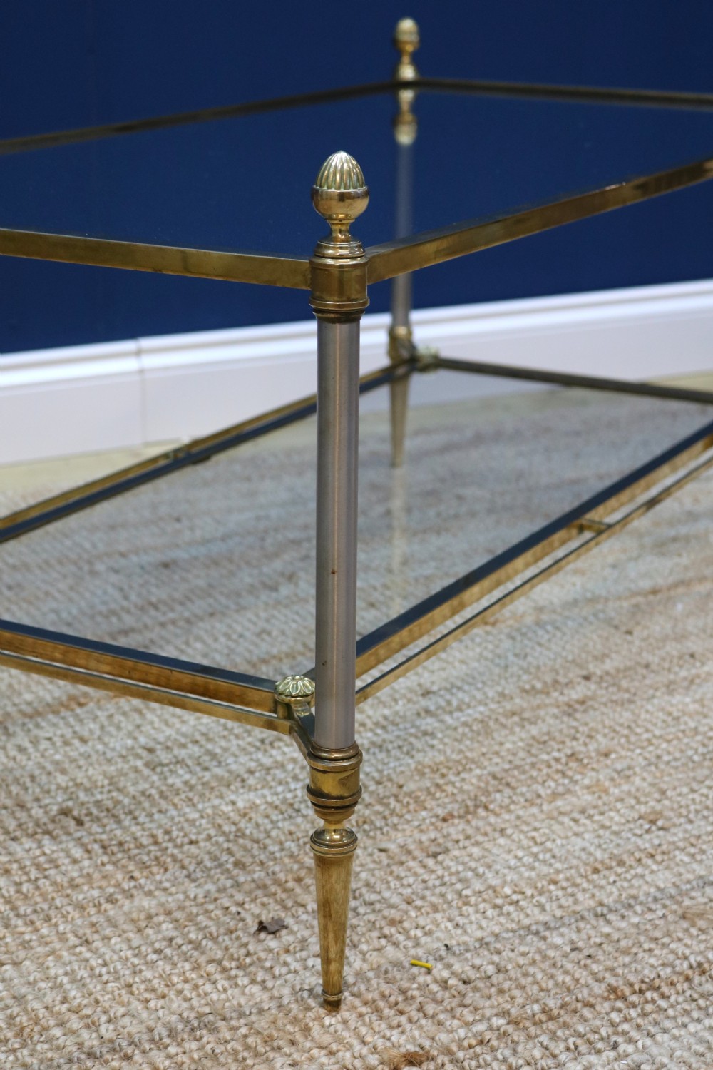 A two-tier rectangular brass and glass coffee table featuring finial corner posts and tapered legs. View X
