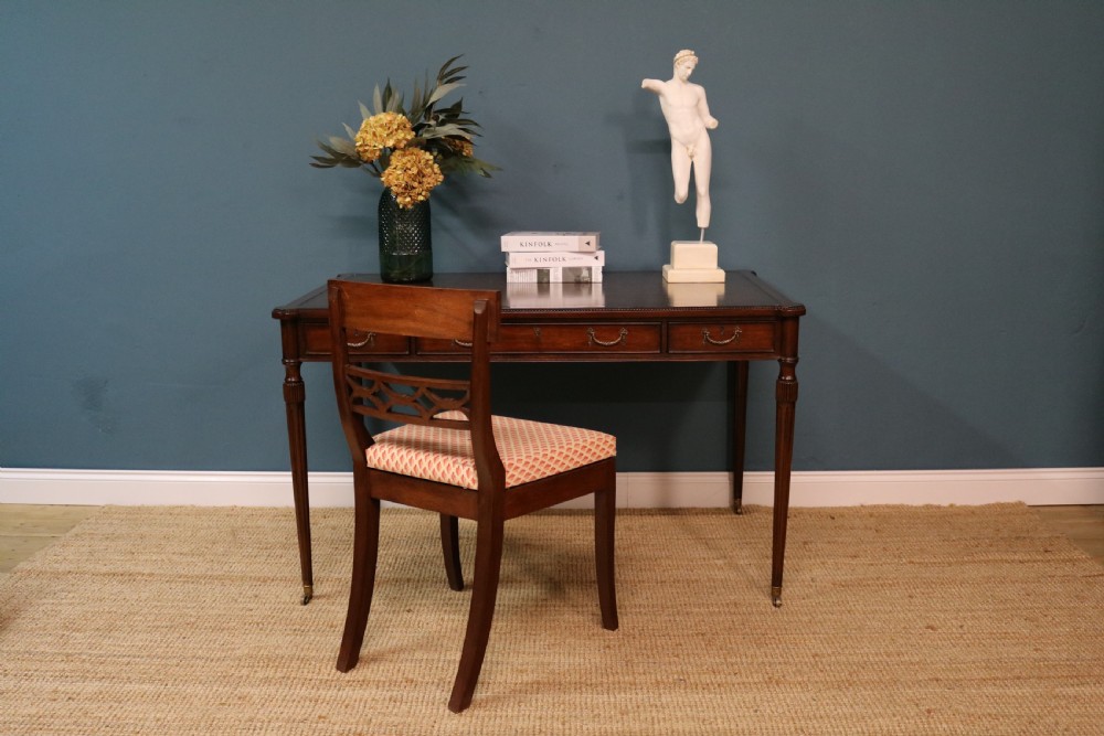A George IV style mahogany writing table featuring frieze drawers with brass handles and reeded tapering legs on brass castors. View VII