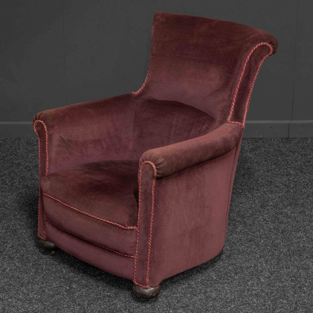 A Victorian armchair upholstered in dark burgundy velvet with braided trim detailing and short turned wooden feet on castors. View III