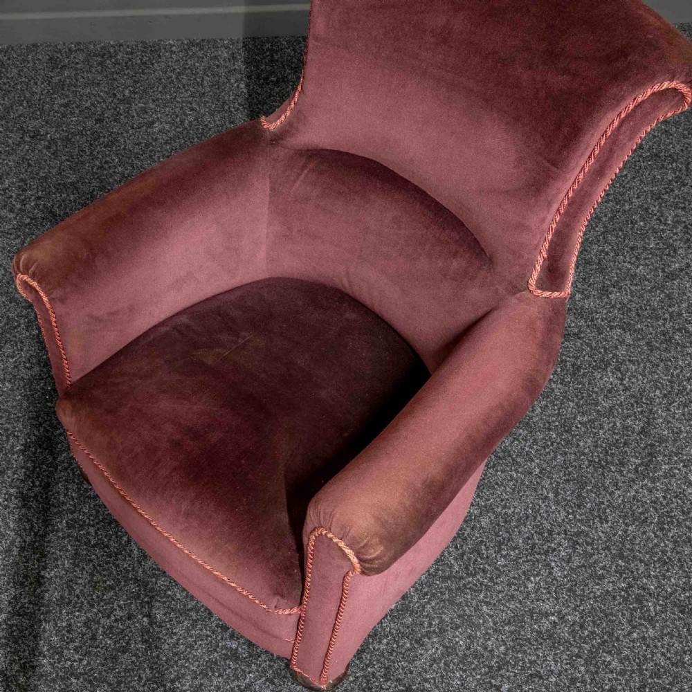 A Victorian armchair upholstered in dark burgundy velvet with braided trim detailing and short turned wooden feet on castors. View IV