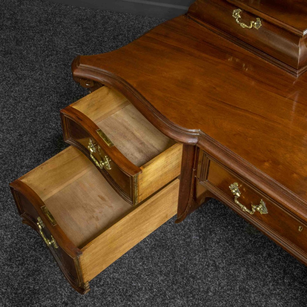 A Victorian carved mahogany dressing table featuring a central swing mirror, small upper jewellery drawers, lower storage drawers, and carved cabriole legs. View II