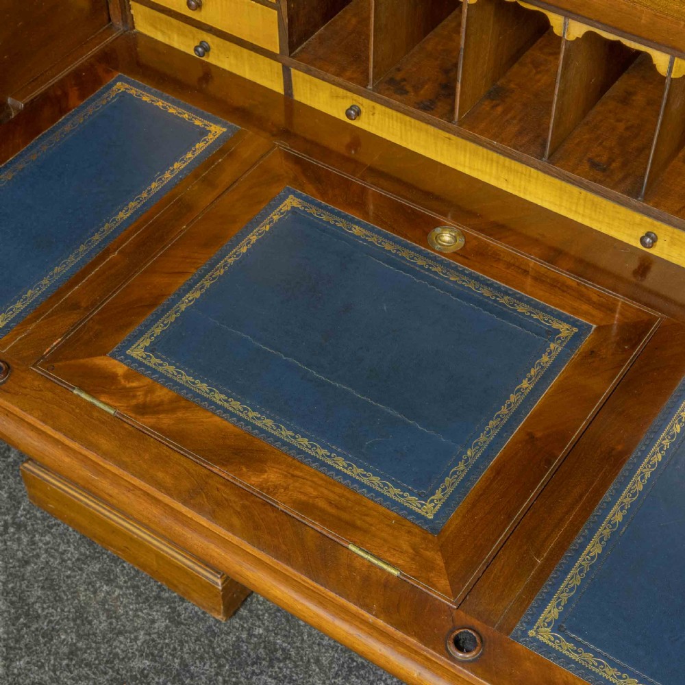 A Sheraton Revival mahogany cylinder desk featuring satinwood crossbanding, twin drawer pedestals, and an extended writing surface fitted with blue leather. View IX