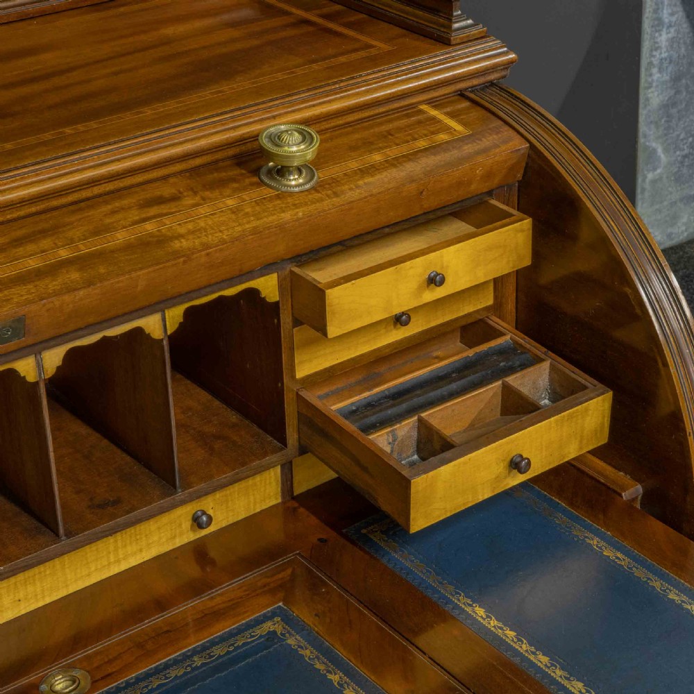 A Sheraton Revival mahogany cylinder desk featuring satinwood crossbanding, twin drawer pedestals, and an extended writing surface fitted with blue leather. View XI