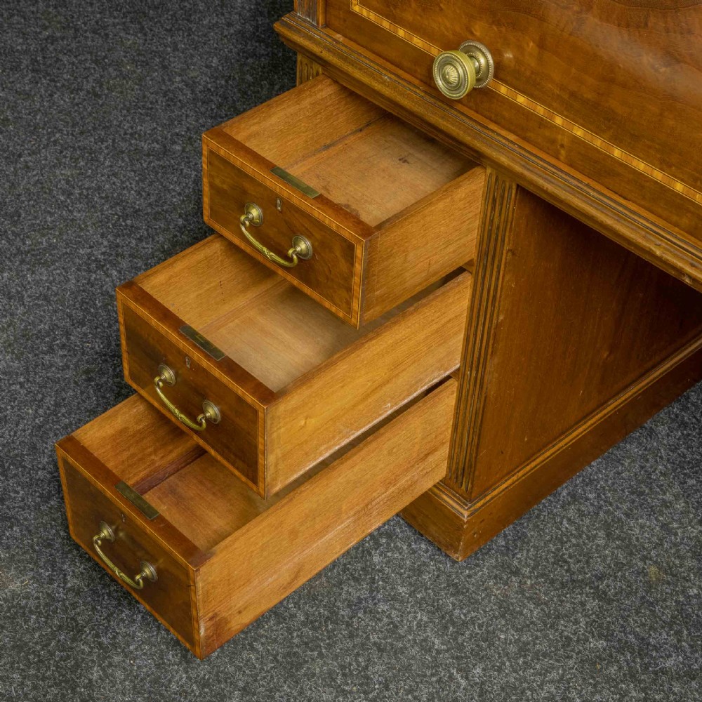 A Sheraton Revival mahogany cylinder desk featuring satinwood crossbanding, twin drawer pedestals, and an extended writing surface fitted with blue leather. View XII