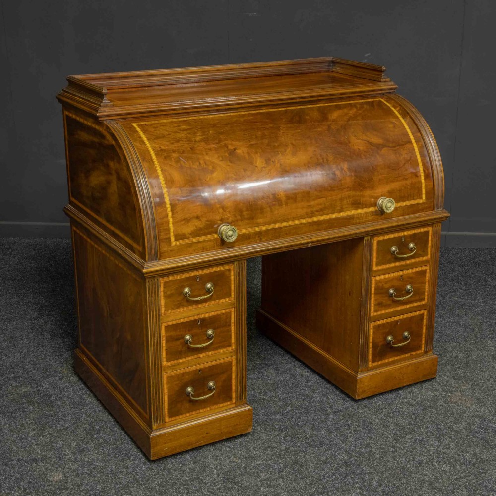 A Sheraton Revival mahogany cylinder desk featuring satinwood crossbanding, twin drawer pedestals, and an extended writing surface fitted with blue leather. View XIII