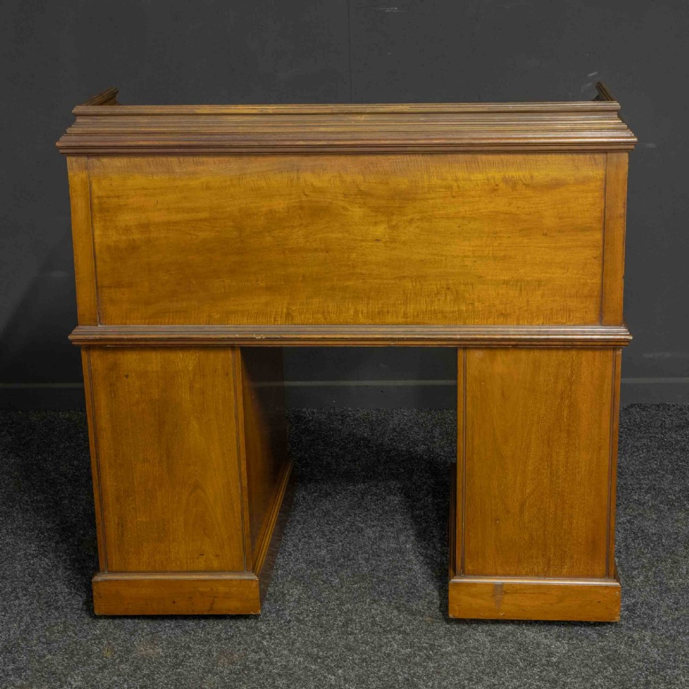 A Sheraton Revival mahogany cylinder desk featuring satinwood crossbanding, twin drawer pedestals, and an extended writing surface fitted with blue leather. View XVII