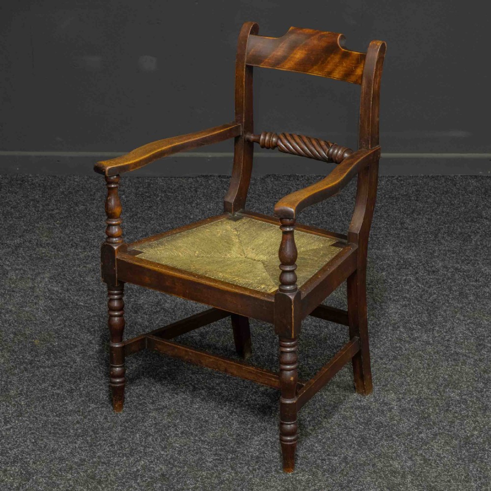 A dark timber provincial Regency armchair featuring a woven rush seat, turned legs, curved arms, and a rope twist back splat. View II