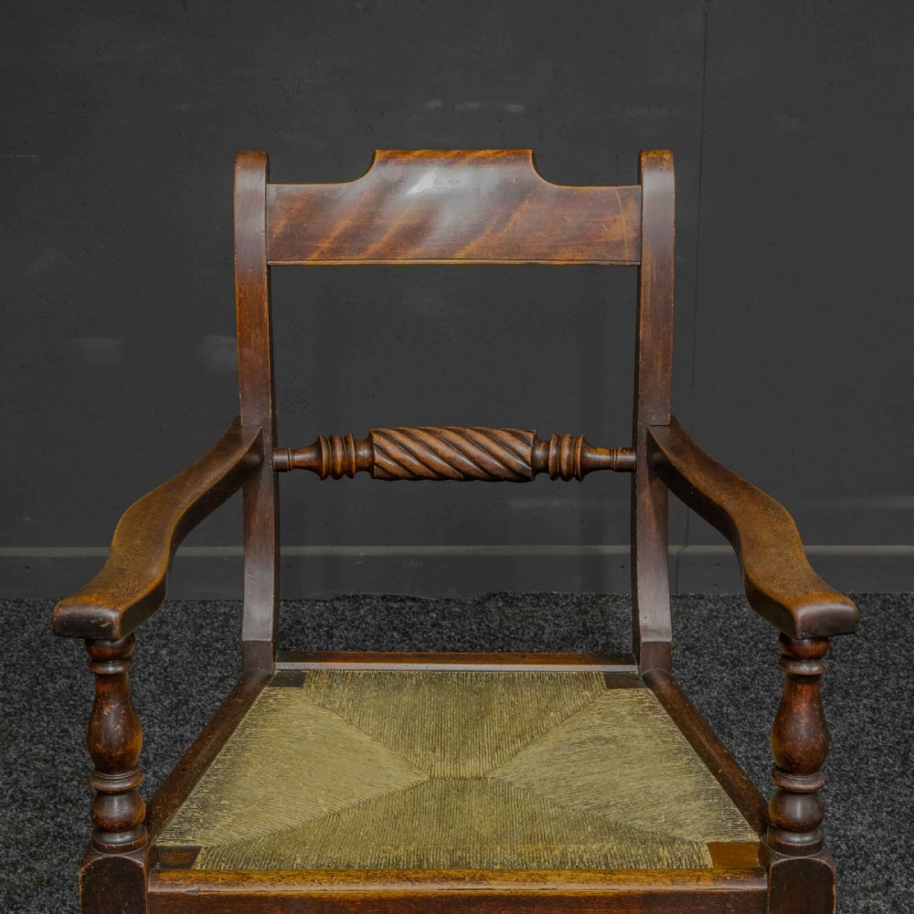 A dark timber provincial Regency armchair featuring a woven rush seat, turned legs, curved arms, and a rope twist back splat. View IV