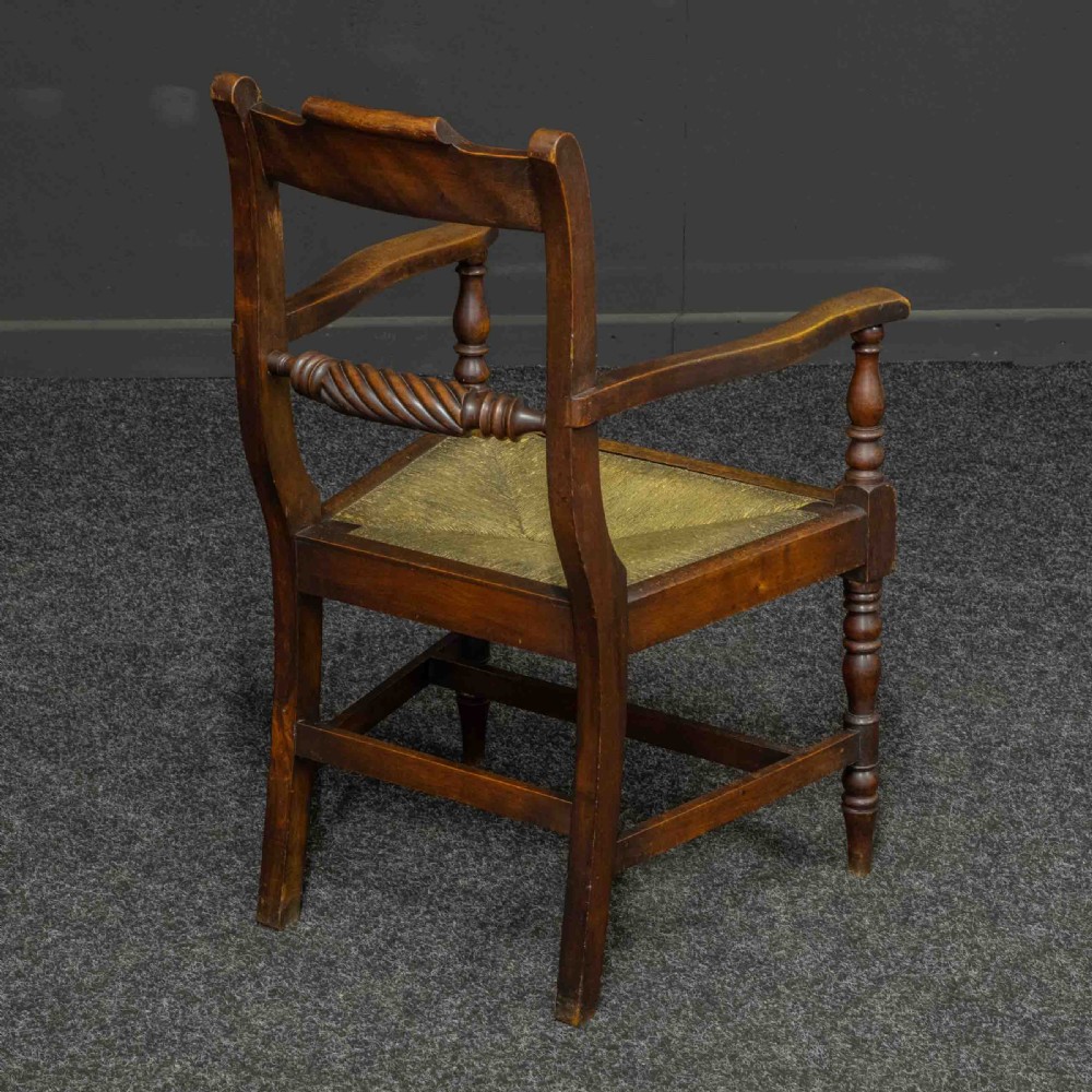 A dark timber provincial Regency armchair featuring a woven rush seat, turned legs, curved arms, and a rope twist back splat. View VI