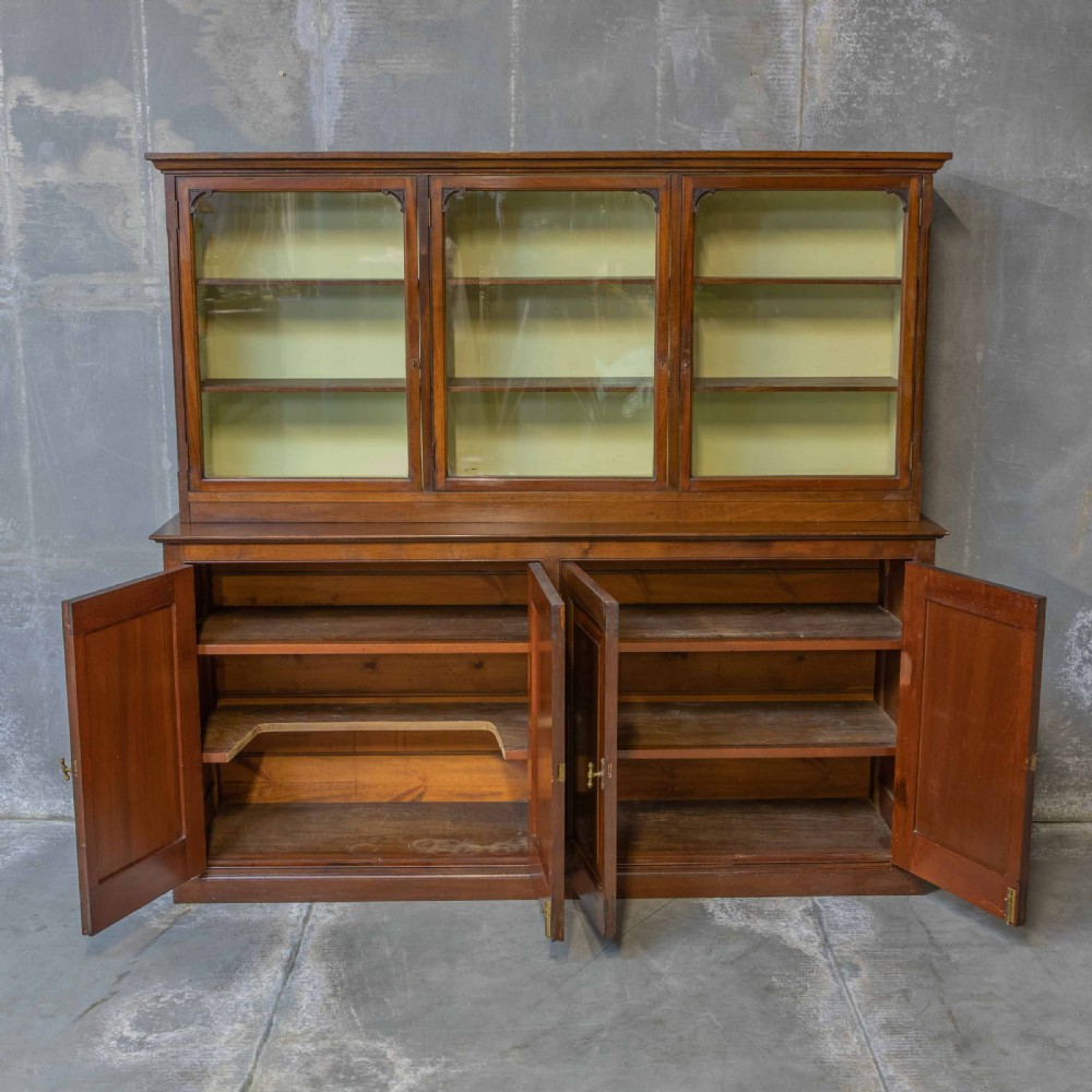 An Edwardian mahogany shop fitting bookcase featuring a three-door glazed upper section with a pale painted interior above a four-door panelled cupboard base. View III