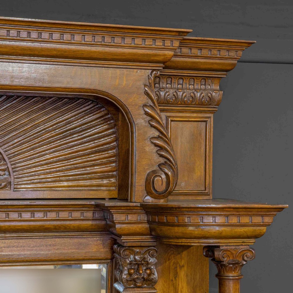A late Victorian carved oak sideboard with a mirrored backboard superstructure, detailed relief carvings, turned pillars, and claw feet. View V