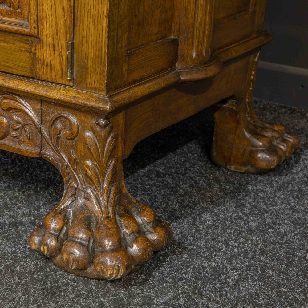 A late Victorian carved oak sideboard with a mirrored backboard superstructure, detailed relief carvings, turned pillars, and claw feet. View X